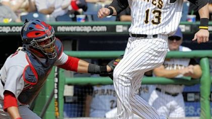 Pirates outfielder Nate McLouth scores as the ball flies over the head of Cardinals catcher Jason LaRue in the first inning  of yesterday's game at PNC Park.