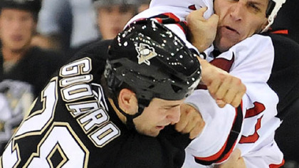 Eric Godard takes a punch from the New Jersey's Mike Rupp early in the home opener last night.