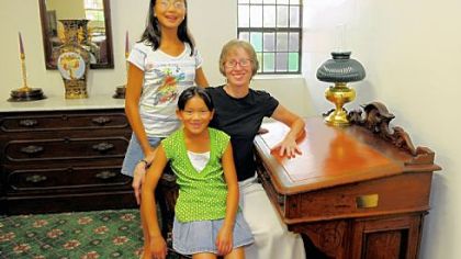 An antique desk that belonged to Charles Craft, founder of Crafton, has been donated by his relatives and will be displayed at Episcopal Church of the Nativity in Crafton. Mr. Craft's great-granddaughter, Sarah Quinn, sits at the desk with daughters, Natalie, 9, also seated, and Elizabeth, 11.