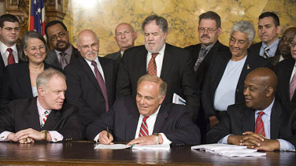 Gov. Ed Rendell signs the budget in Harrisburg yesterday. He is flanked by Majority Leader H. William DeWeese, left, and Appropriations Committee Chairman Dwight Evans.