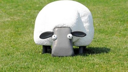 The electric robotic-sheep lawn-mower on the lawn in front of the Phipps Conservatory and Botanical Gardens. The robotic sheep is one of 11 "BigBots" on display around Pittsburgh as part of the Robotics Institute at CMU Robot 250 Festival.