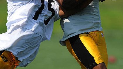 Pittsburgh Steelers receiver Willie Reed has a pass intercepted by Anthony Smith during afternoon workouts at St. Vincent College yesterday.