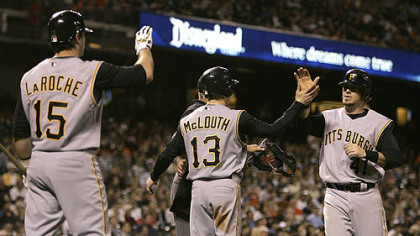 Andy LaRoche (15) and Nate McLouth (13) congratulate teammate Ryan Doumit after scoring against the San Francisco Giants during the seventh inning of yesterday's baseball gam in San Francisco.
