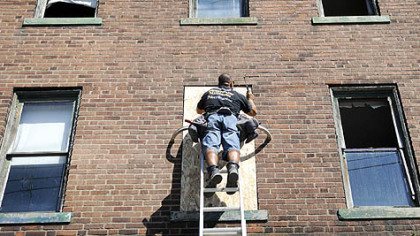 Lou Kavulic, of Green Tree, a volunteer with RenewPittsburgh, boards up the windows of the historic August Wilson House in the Hill District during the organizations clean-up of the property yesterday.