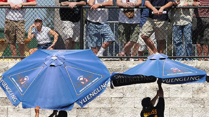Players in the bullpen struggle with umbrellas as fans watch yesterday in Clearwater, Fla.
