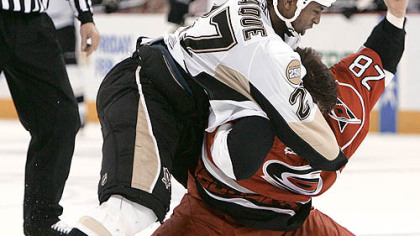 The Penguins' Georges Laraque and the Hurricanes' Wade Brookbank fight in the first period.
