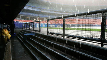 Heavy rain falls into the visitors dugout before the Pirates game against the Mets at Shea Stadium was postponed because of rain in New York.
