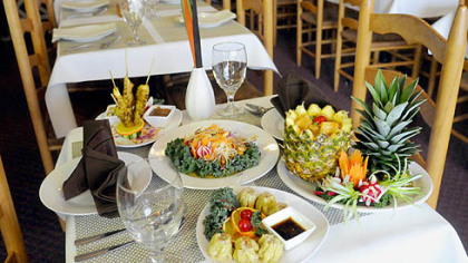 Nicky's Thai Kitchen features, from front counter-clockwise, Steamed Dumplings, Thai-style dumpling pork served with sweet and sour black soy sauce; Pineapple Curry, choice of meat mixed with pineapple chunks, tomatoes, peas, carrots and red curry paste; Papaya Salad; and Chicken Satay, marinated chicken on skewers, grilled and served with peanut sauce.