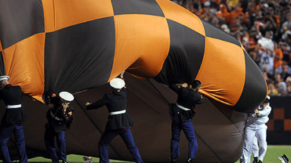 Marines try to hold down a Browns banner in the strong winds before the National Anthem last night at Cleveland Browns Stadium.