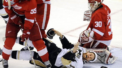 Ryan Malone loses his gloves in between the Red Wings' Niklas Kronwall and Chris Osgood in the second period Monday night.
