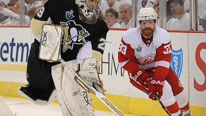 Marc-Andre Fleury handles the puck past the Red Wings' Kris Draper.