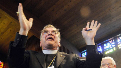 Bishop Robert Duncan is applauded by the convention. At right is diocesan trustee Robert Fleming.