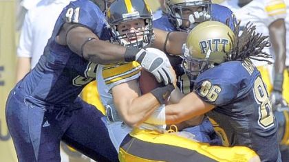 Greg Romeus, Aaron Berry and Austin Ramson swarm Iowa quarterback Ricky Stanzi.
