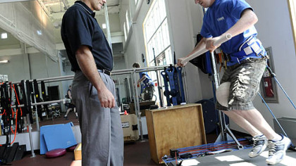 Brian Hagen, program administrator of the UPMC Sports Medicine Concussion Program, watches as high-level motocross racer Broc Hepler, a concussion patient, does physical therapy at the UPMC South Side complex.