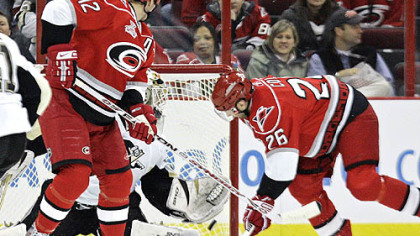The Hurricanes' Erik Cole, right, scores against Penguins goalie Dany Sabourin as Eric Staal (12) looks on in the first period last night in Raleigh, N.C.