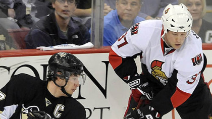 The Penguins' Sidney Crosby works from his knees against Ottawa's Dean McAmmond in the first period of Game Two last night at Mellon Arena.