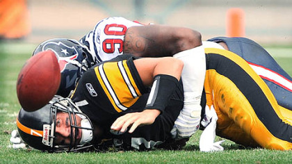 Williams lies on Roethlisberger after causing a fumble.