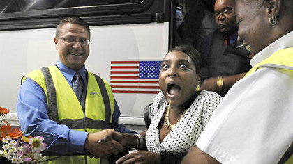 Alexis Brown, center, of Edenton, N.C., reacts as she is welcomed with flowers by Jeffery Driscoll, left, and Theresa Perry of Greyhound yesterday as the first passenger to arrive at Greyhound?s Pittsburgh station at the new Grant Street Transportation Center, Downtown. The $50 million center includes the bus terminal and two city parking garages, one of which also opened yesterday. Greyhound has been operating from a temporary terminal along Second Avenue during the center?s construction.