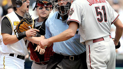 Doug Mientkiewicz, left, and Diamondbacks starter Randy Johnson are restrained by umpire Jeff Kellogg and Arizona catcher Miguel Montero in the third inning yesterday at PNC Park.