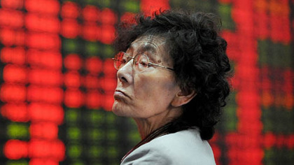 SHANGAI, China -- An investor watches a stock price board at a private securities firm Oct. 13. Chinese share prices closed up 3.65 percent as financial companies and property developers rebounded, erasing early losses. The benchmark Shanghai Composite Index, which covers A and B shares, was up 73.00 points at 2,073.57 on turnover of 41.9 billion yuan equivilent to 6.1 billion.