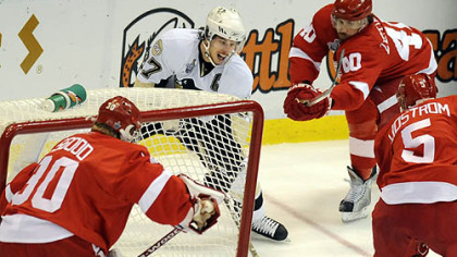 Detroit's  Henrik Zetterberg, rear, and Nicklas Lidstrom converge on Sidney Crosby behind Red Wings goaltender Chris Osgood in the first period.