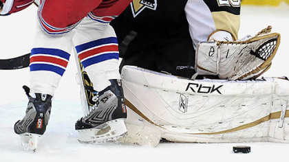 Penguins goalie Marc-Andre Fluery makes a save on Rangers Scott Gomez.