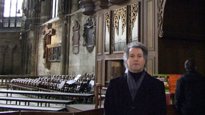 Incoming Pittsburgh Symphony music director Manfred Honeck stands in the famous St. Stephen's Cathedral in Vienna. Behind him is the area in which he sat as part of an orchestra that played during Masses.