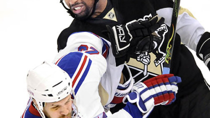Penguins Georges Laraque gets tied up with Rangers Fredrik Sjostrom in the first period.