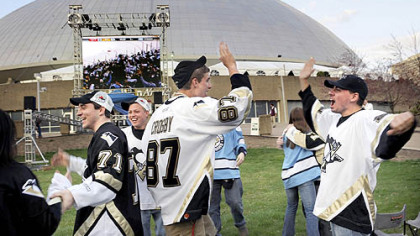 Penguin fans celebrate their team's first goal against Ottawa as they watch the game on a large screen television outside Mellon Arena last night.