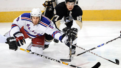 Sidney Crosby and the Rangers' Dan Girardi dive for the puck in the first period Sunday afternoon.