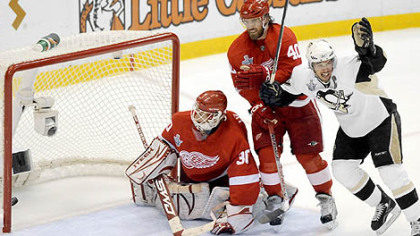 Penguins' Sidney Crosby celebrates Marian Hossa's goal in front of Red Wings Chris Osgood and Henrik Zetterberg in the first period Monday night.