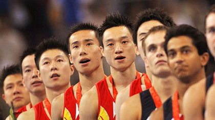 Teams pose on the podium after the team finals of the artistic gymnastics event. China's team, at left, won the gold. Japan's team, not shown, won silver and the United States' team, at right, won  bronze.