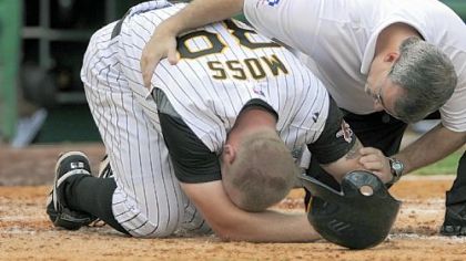 The Pirates' Brandon Moss is checked by athletic trainer Brad Henderson after spraining his left ankle in the seventh inning.