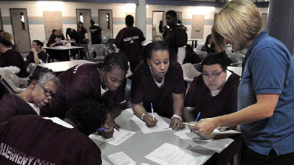 From left, Charlotte Lee, 52, of Homewood, Devan Posten, 39, of Wilkinsburg, Melee Shorter, 31, of Bellevue, and Olivia Zubik, 20, of Bethel Park, fill out voter registration forms with help from Cindy Walter, a faculty member of the School of Nursing at Duquesne University. Volunteers from many community groups conducted the voter registration drive at Allegheny County Jail.