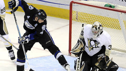 Penguins goalie Ty Conklin stops a shot from between the legs of Lightning center Vincent Lecavalier in the first period last night in Tampa, Fla.