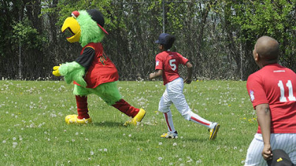 DeAngelo Houston, 13, from the Hill District and a member of the Pittsburgh Crawfords chases the Pirate Parrot in the outfield of the newly dedicated Josh Gibson Fields in the Hill District Tuesday, May 6, 2008.
