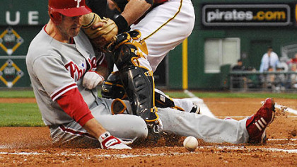 The Phillies' Chase Utley scores as the ball gets away from Ryan Doumit.