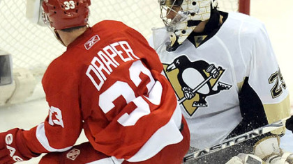 Detroit's Kris Draper crashes the net on Marc-Andre Fleury as the puck caroms off the crossbar last night.