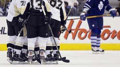 Penguins players celebrate a goal by Mark Eaton as Toronto Maple Leafs defenseman Pavel Kubina, right, skates by during second period preseason hockey action yesterday in Toronto.
