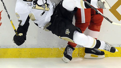 The Red Wings' Brad Stuart checks Petr Sykora into the board in the second period last night at Joe Louis Arena in Detroit.
