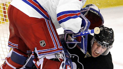Penguins Evgeni Malkin gets caught up underneath Rangers goalie Henrik Lundqvist in the third period Sunday.