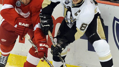 Sidney Crosby passes the puck around the Red Wings' Nicklas Lidstrom.