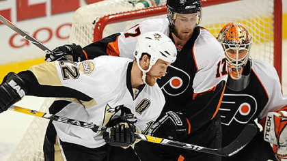 Penguins Ryan Malone tries to tip the puck in past Flyers goalie Martin Biron.