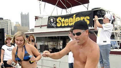 Fans Laura Sendacook of South Park and "Goob" Jenkins of West View dance to the music from a disc jockey aboard one of the "Steelers' Navy" boats outside Heinz Field.