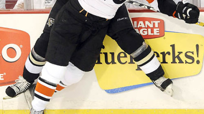 The Penguins' Jarkko Ruutu checks the Flyers' Mike Richards along the board in the second period last night.
