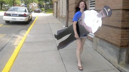 Michele Smith carries a cutout of Bellevue police chief Matthew Sentner.