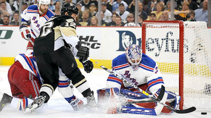 Penguins Ryan Malone attempts to one hand the puck past Rangers goalie Henrik Lundqvist.