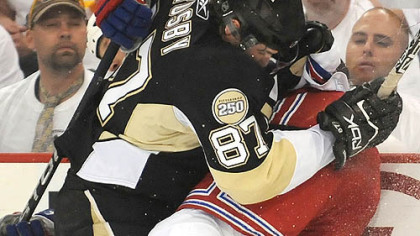Sidney Crosby checks the Rangers Colton Orr in to the boards.