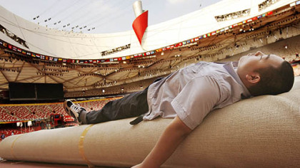 BEIJING -- A worker naps in the Bird's Nest the day after the closing ceremony.