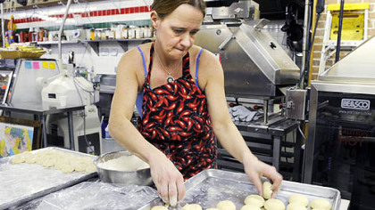 Linda Jones dips dough balls in flour before a machine flattens them into warm tortillas at Reyna Foods on Penn Avenue in the Strip District. Reyna recently started making its own corn and wheat-flour tortillas.